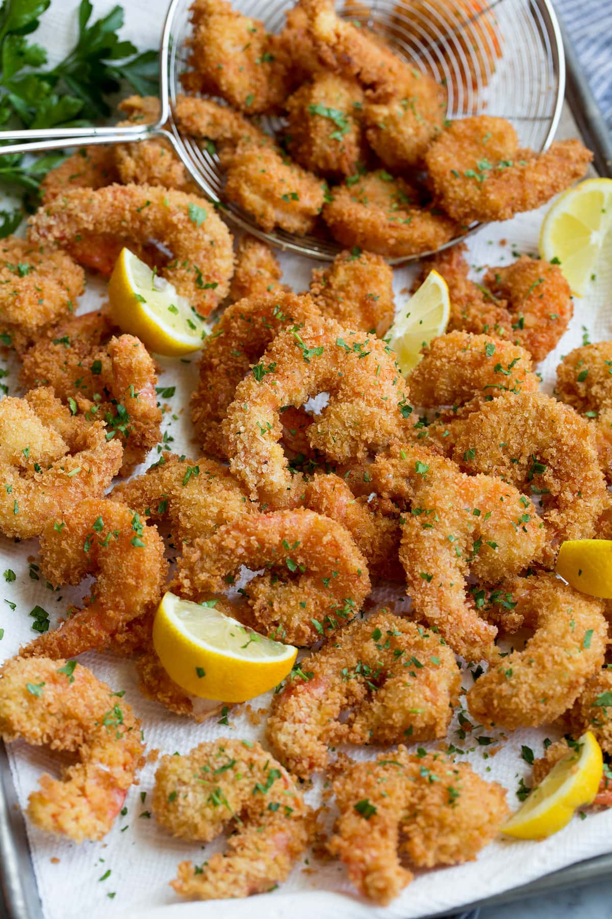 Close up photo of shrimp piled on paper towel lined sheet pan.