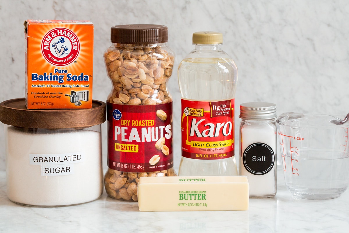 Photo of ingredients used to make peanut brittle. Includes sugar, baking soda, peanuts, butter, corn syrup, salt and water.