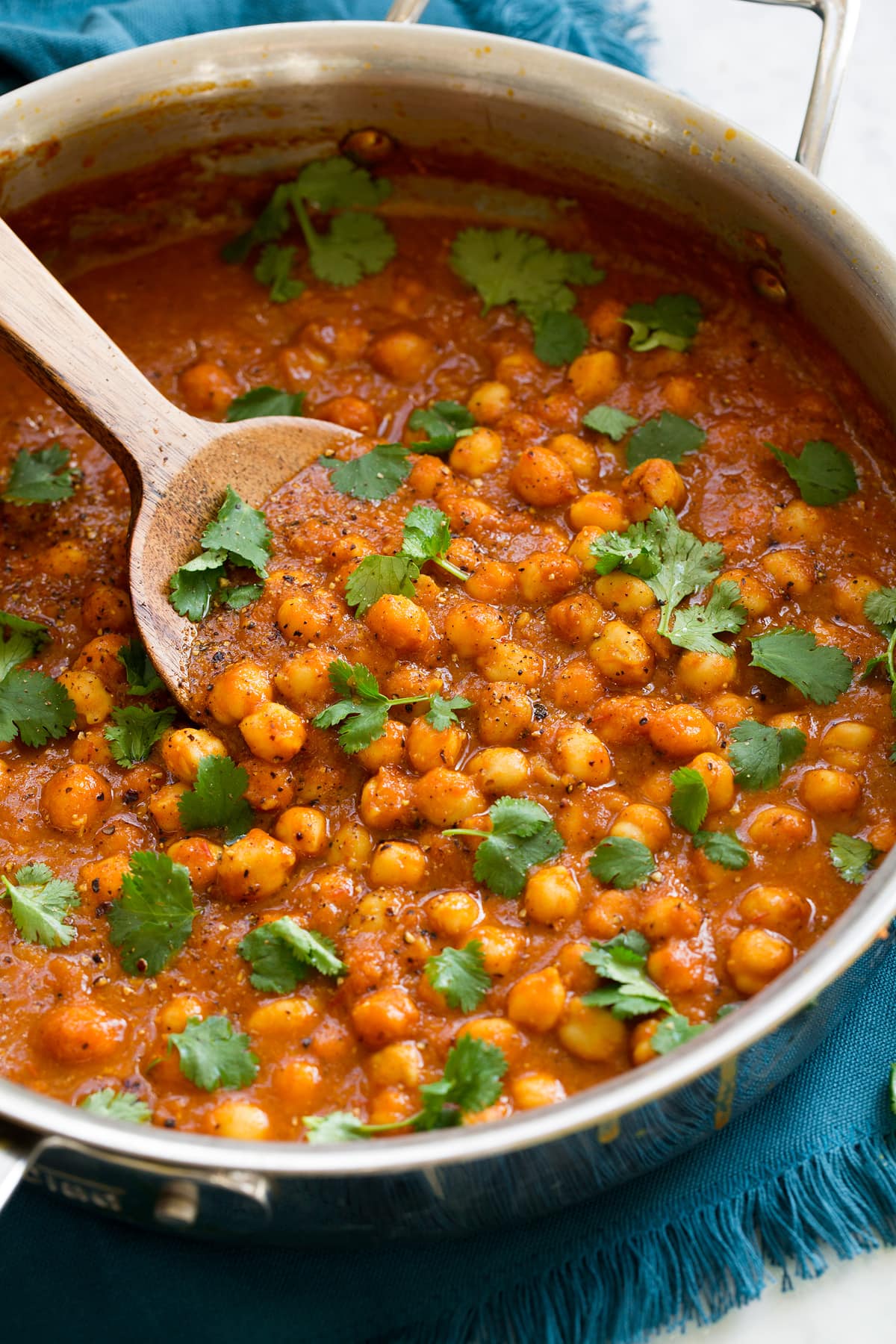 Chickpea curry in a saute pan shown from a side angle.