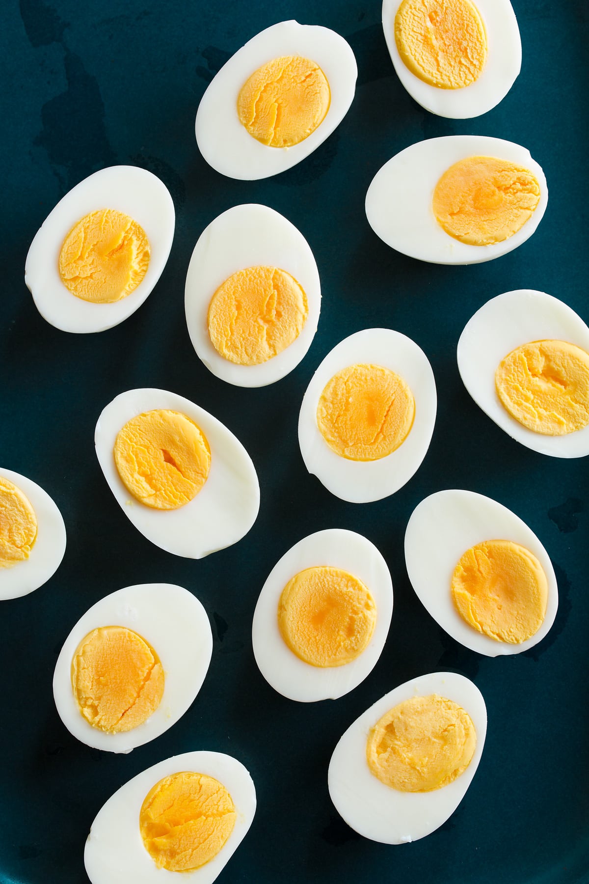 Overhead photo of steamed eggs cut in half on a blue platter.