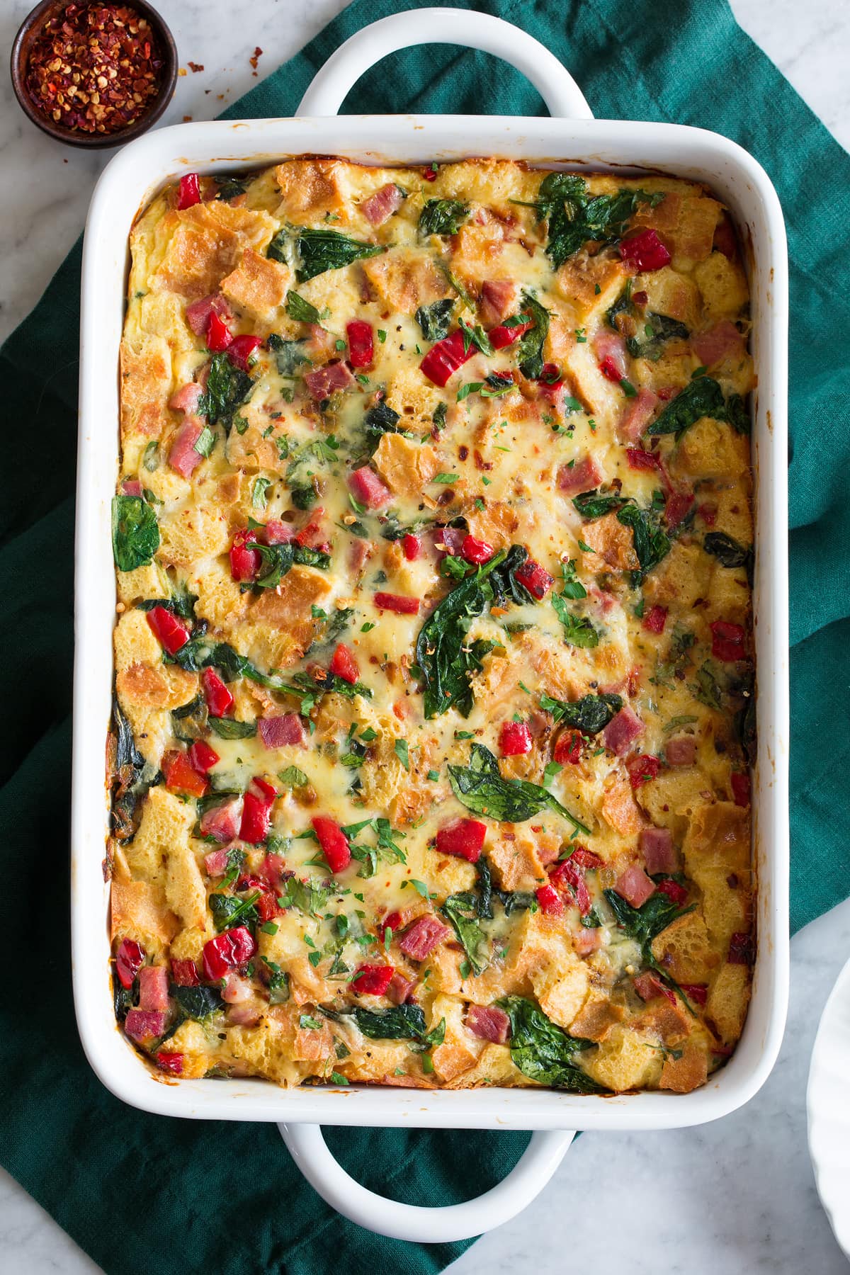 Overheat photo of strata casserole in a white rectangular baking dish.