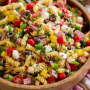 Italian pasta salad shown from a side angle on a large wooden bowl.