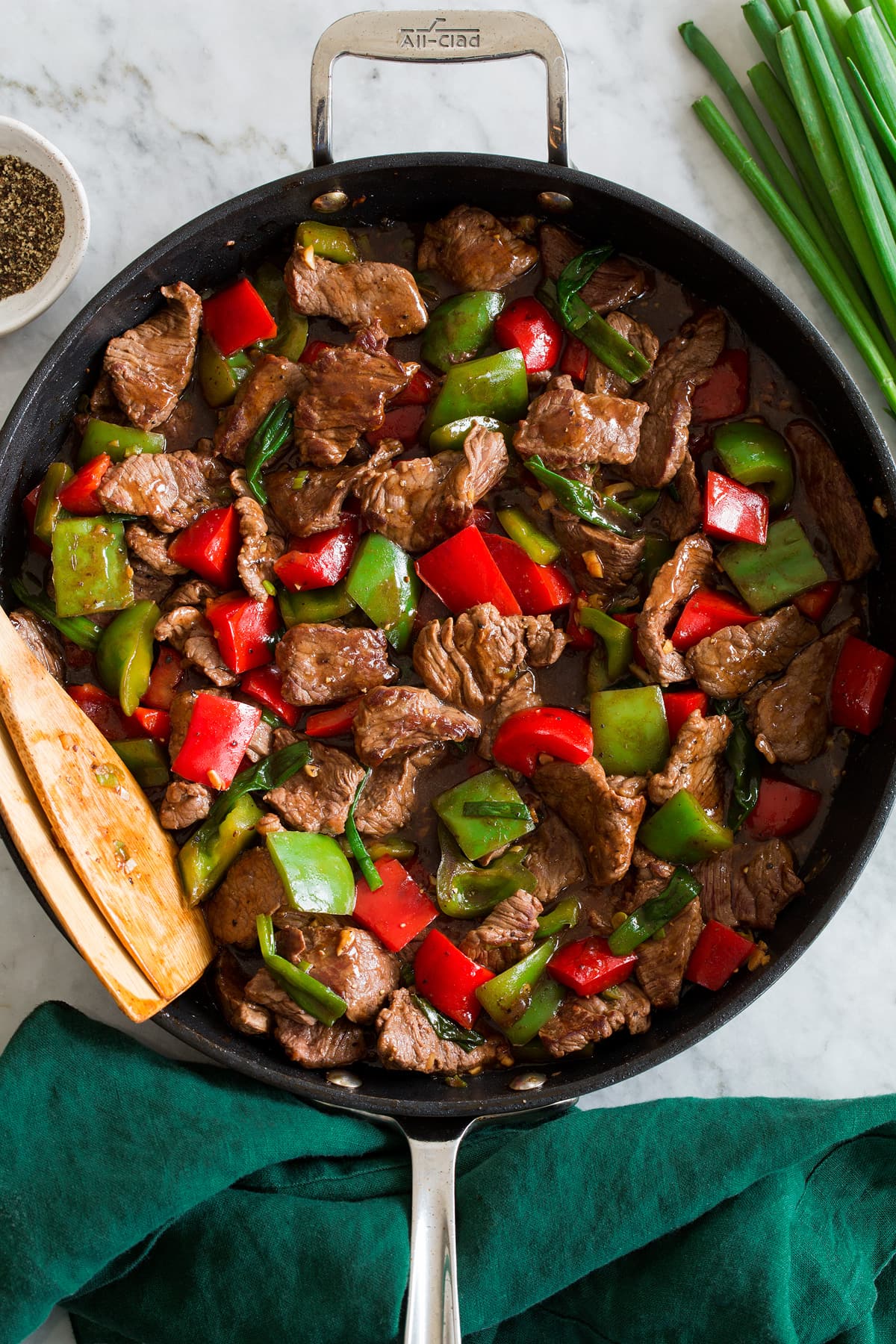 Photo: Pepper steak and bell peppers shown in a dark skillet from above.