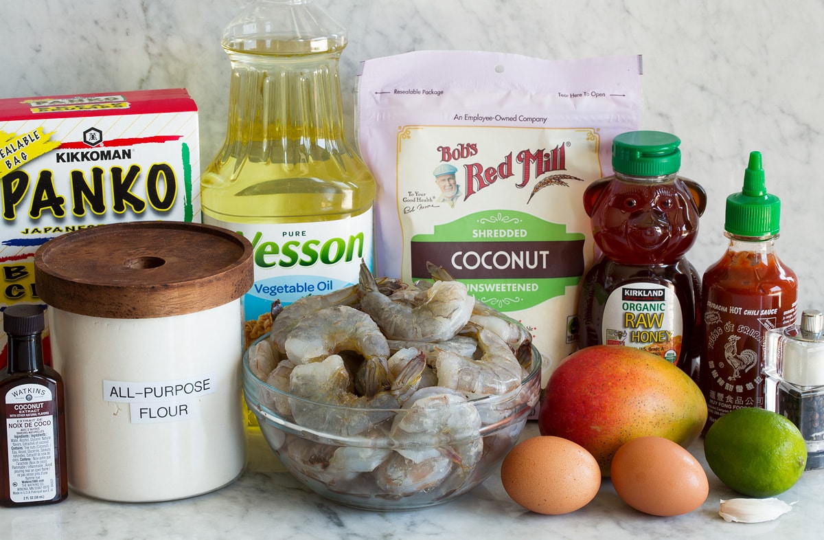 Photo: Ingredients used to make coconut shrimp. Includes shrimp, flour, shredded coconut, panko, eggs, honey, mango, sriracha, lime, coconut extract, salt and pepper.