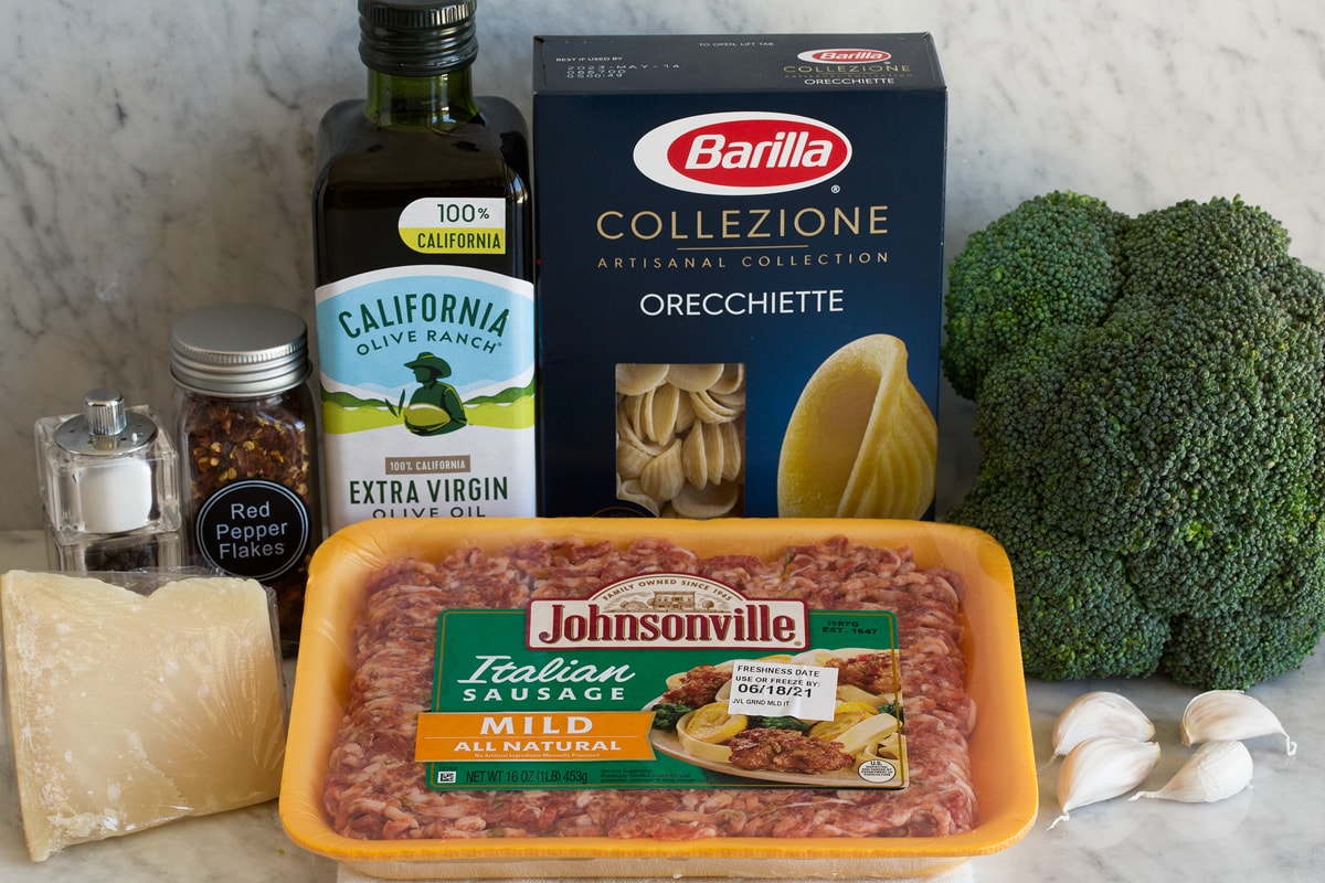 Photo: Ingredients used to make orecchiette with sausage and broccoli shown. Includes Italian sausage, pasta, broccoli, olive oil, garlic, parmesan, red pepper flakes, salt and pepper.