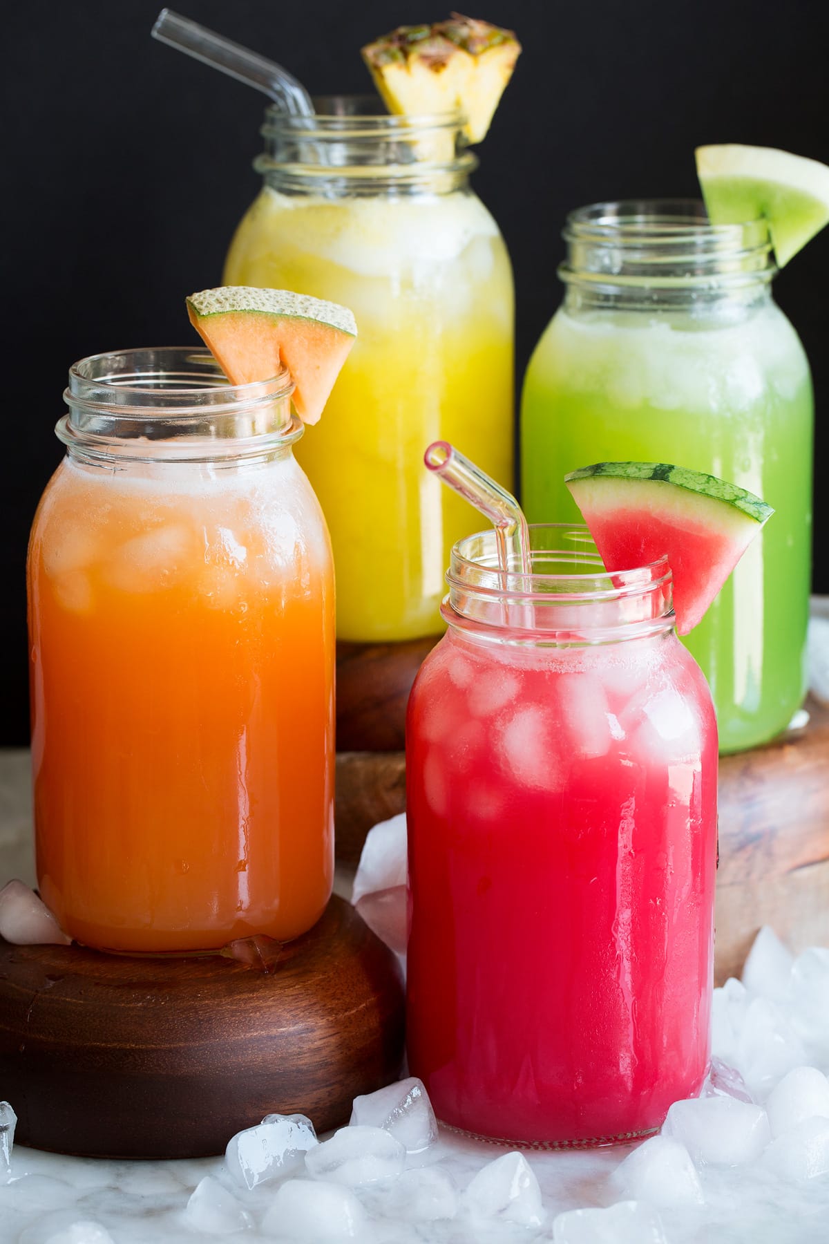 Photo: Four types of aqua fresca including watermelon, cantaloupe, honeydew and pineapple shown in glass mason jars.