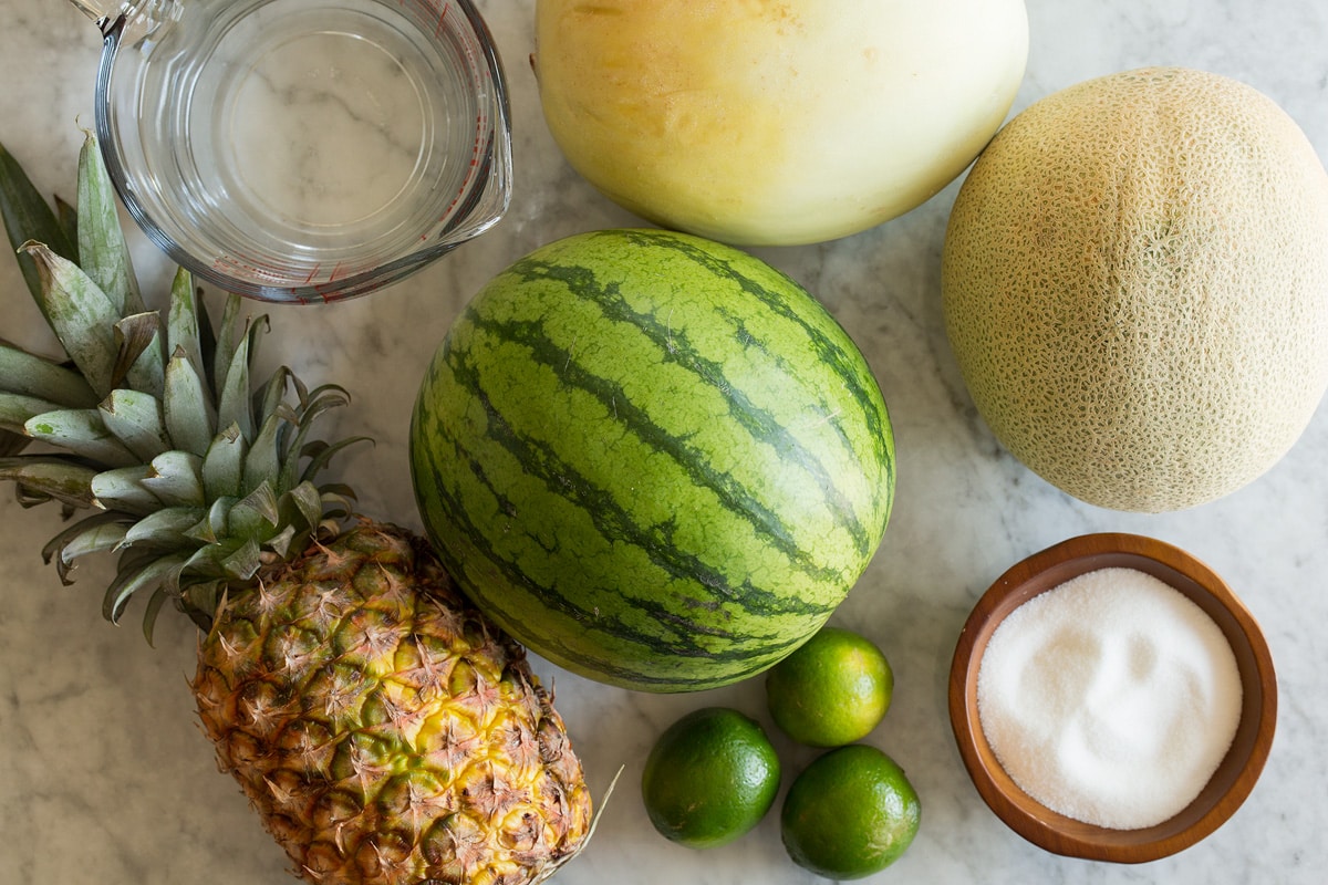 Photo: Ingredients used to make aqua fresca. Includes watermelon, cantaloup, honeydew, pineapple, limes, and sugar.