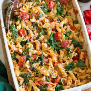 Photo: Baked feta pasta in a white rectangular baking dish shown from a side angle.