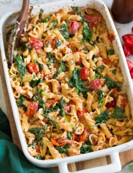 Photo: Baked feta pasta in a white rectangular baking dish shown from a side angle.