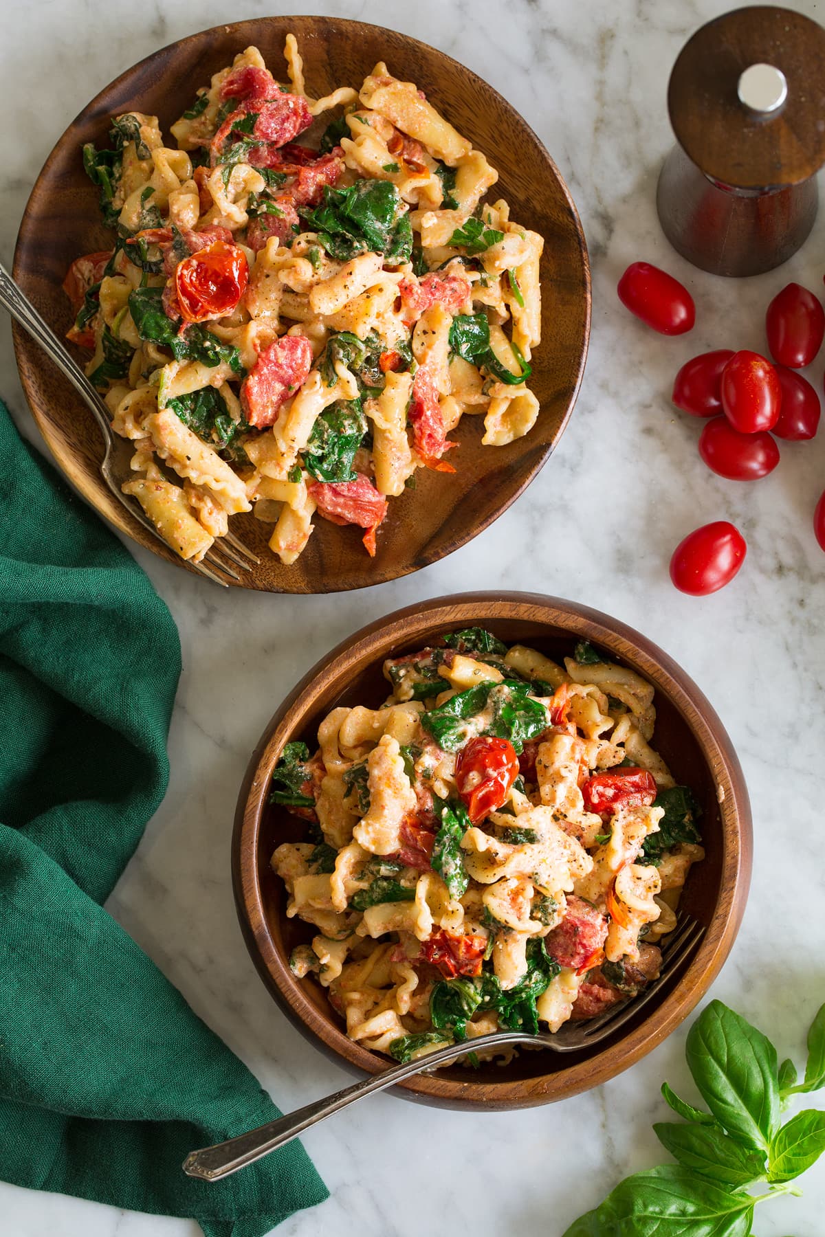 Photo: Two servings of tiktok baked feta pasta shown from above on a white marble surface.