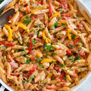 Photo: Creamy cajun chicken pasta shown in a large white pan from overhead.