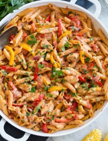 Photo: Creamy cajun chicken pasta shown in a large white pan from overhead.