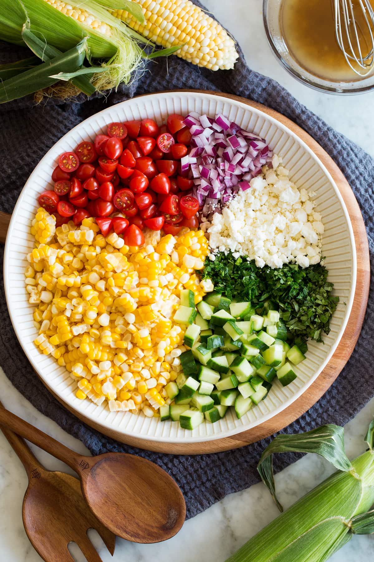 Photo: Corn salad ingredients shown divided into areas before tossing in a bowl. It is shown from above.