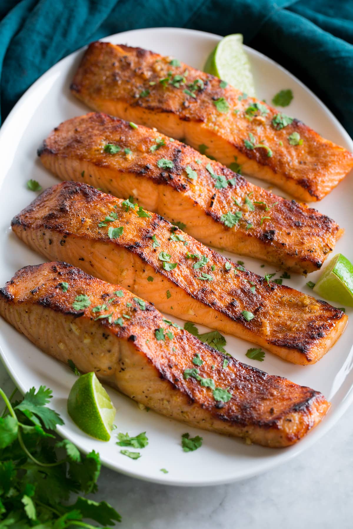 Broiled Salmon shown on a serving platter in a row of four.