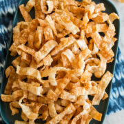 Overhead photo of crispy wonton strips on a rectangular platter.