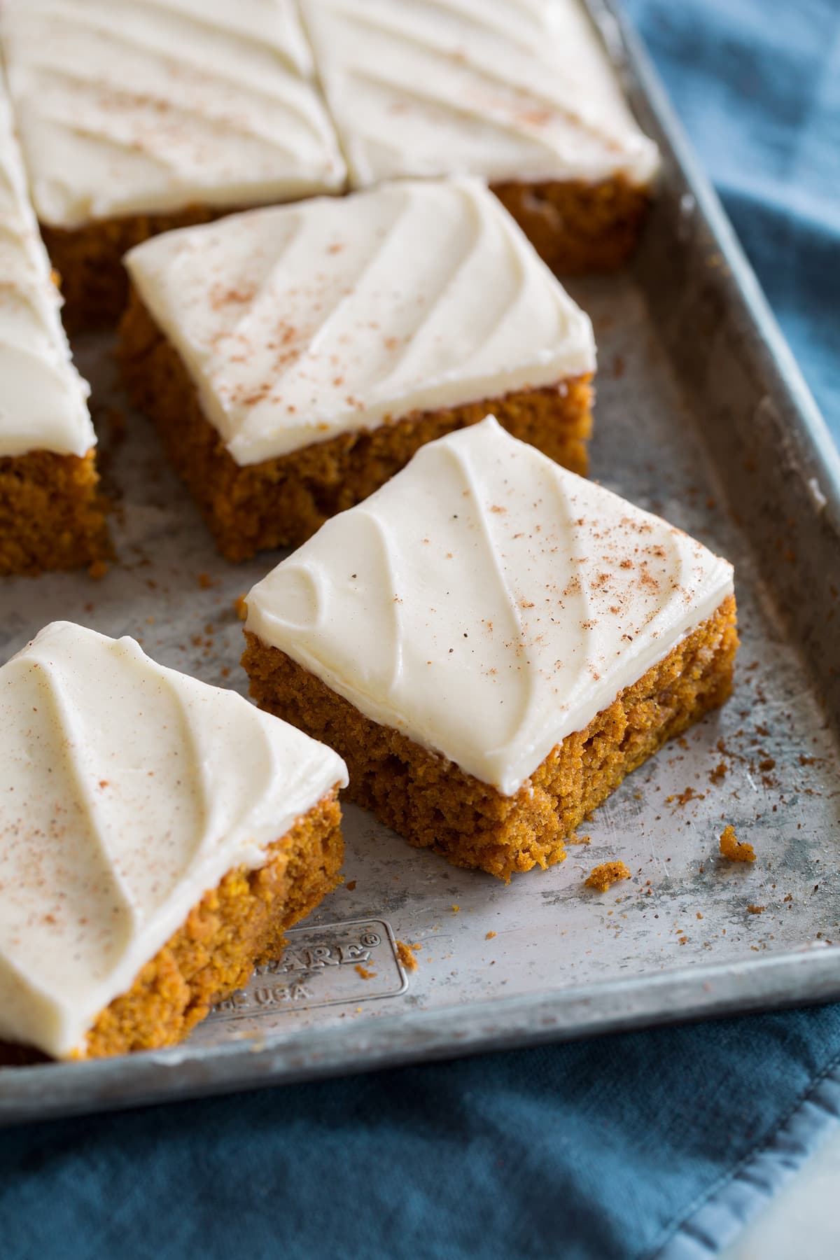 Close up photo of sliced pumpkin bars on baking sheet.