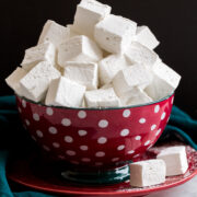 Homemade marshmallows stacked in a red and blue polkadot bowl.