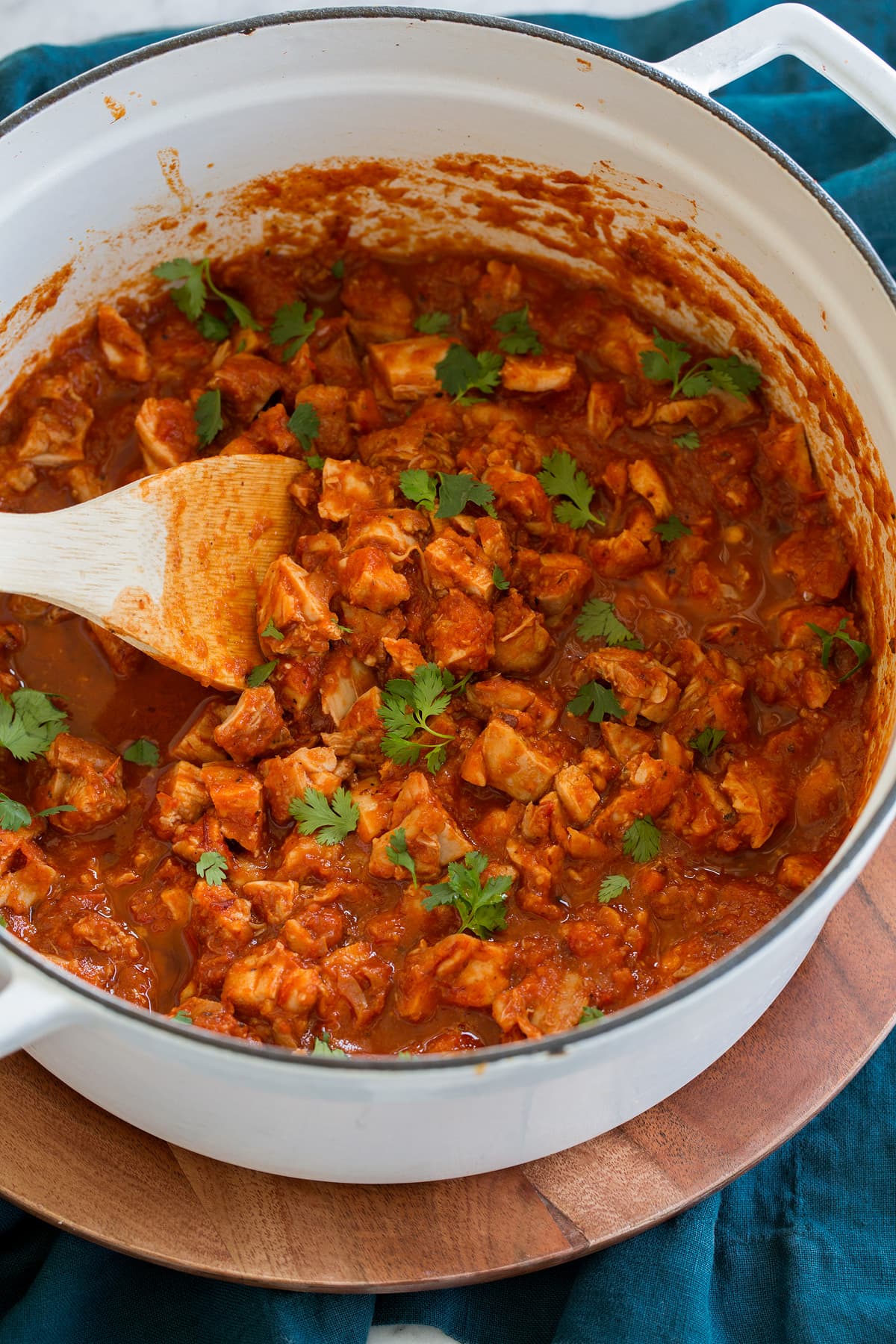 Cooked shredded chicken tinga in a large white pot.