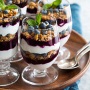 Yogurt Parfaits layered with plain Greek yogurt, blueberry sauce and granola.