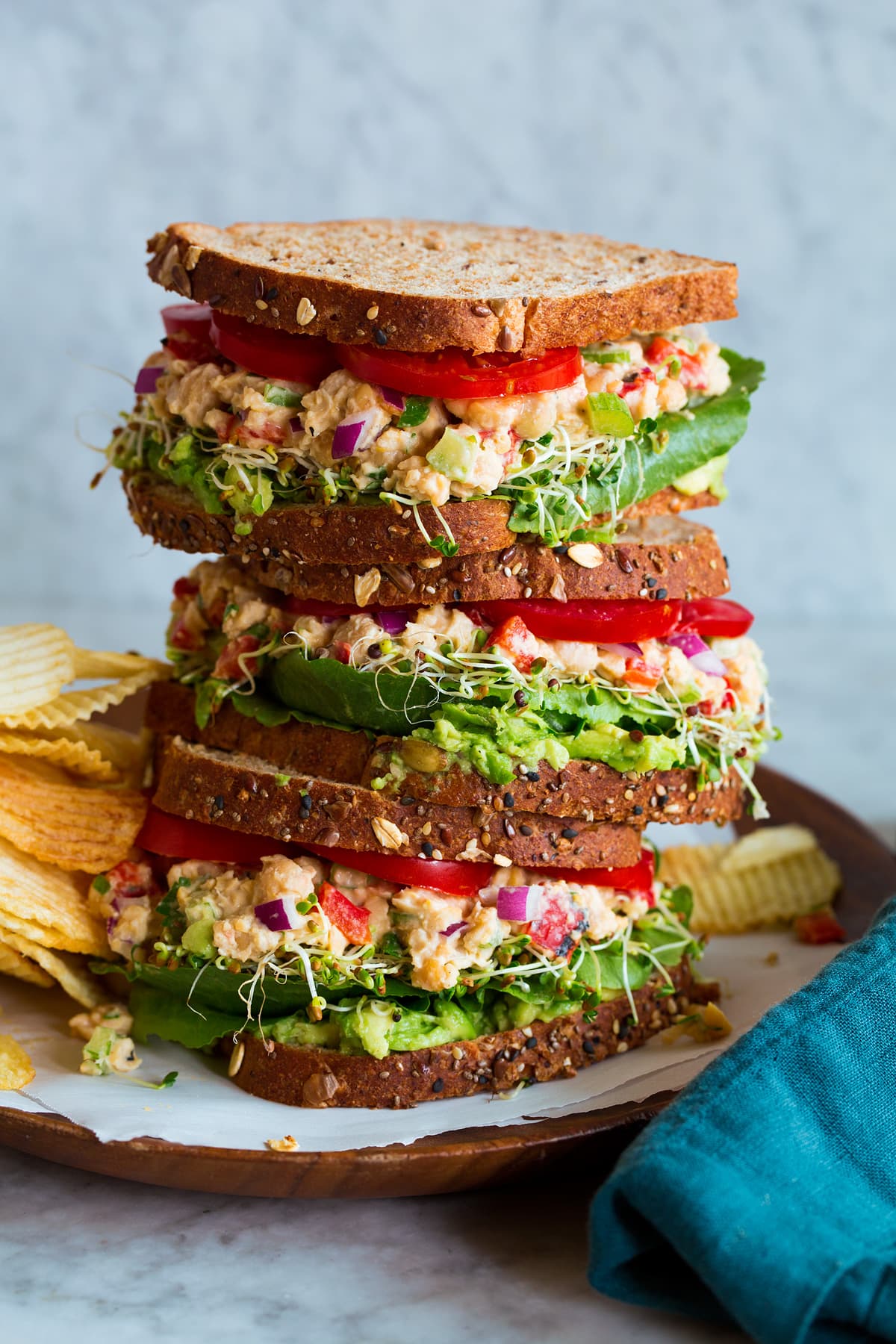 Stack of three chickpea salad sandwiches on multigrain bread.