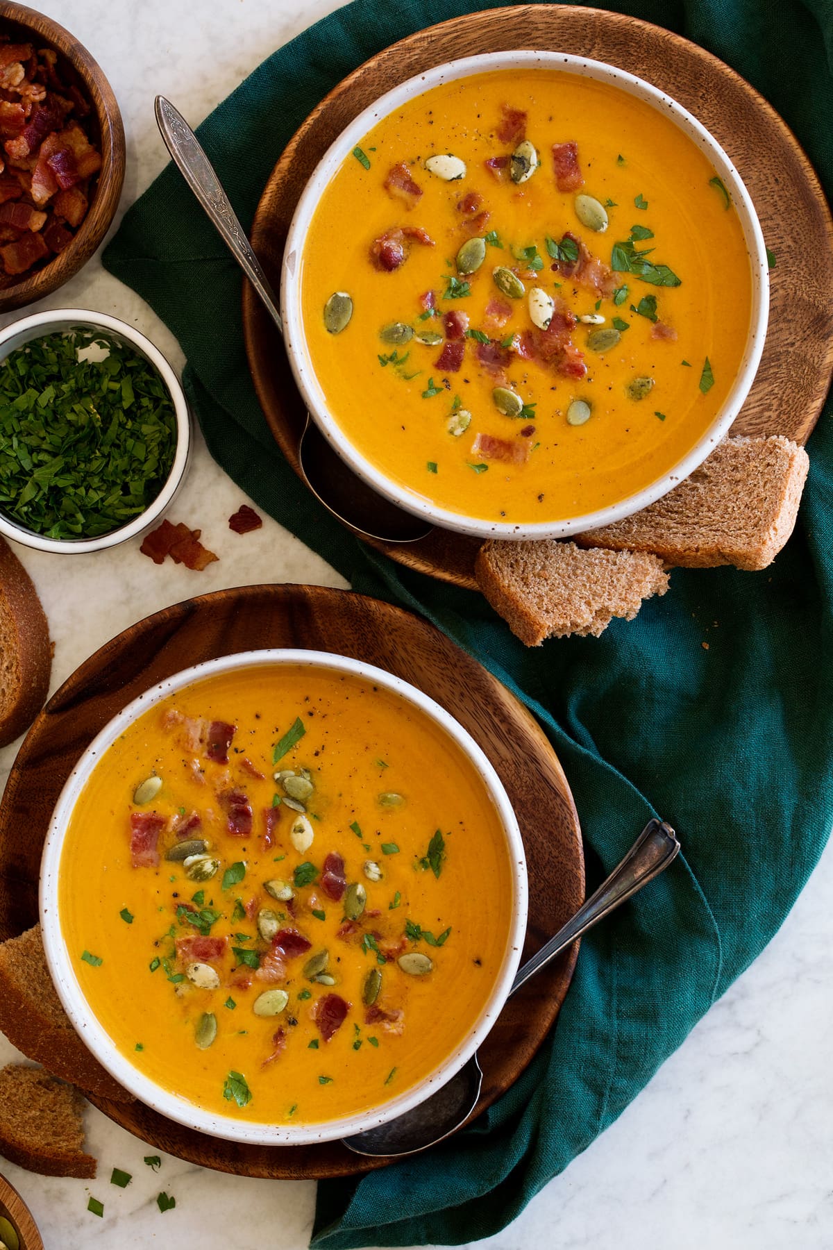 Two servings of pumpkin soup shown from overhead.