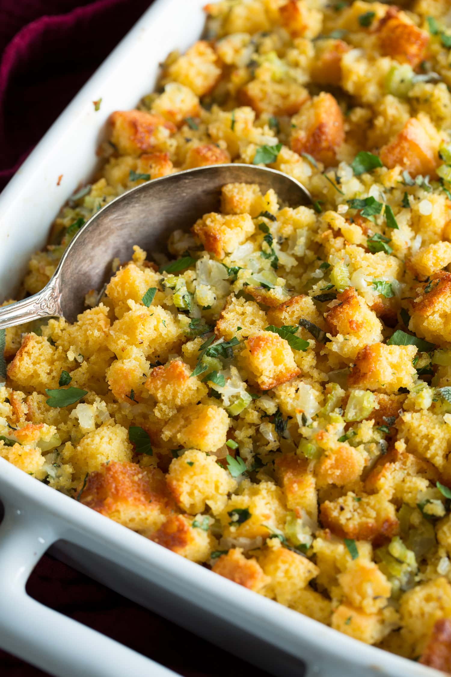 Close up photo showing stuffing being scooped from baking dish.