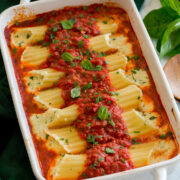 Homemade manicotti stuffed with cheese in a baking dish with marinara sauce.