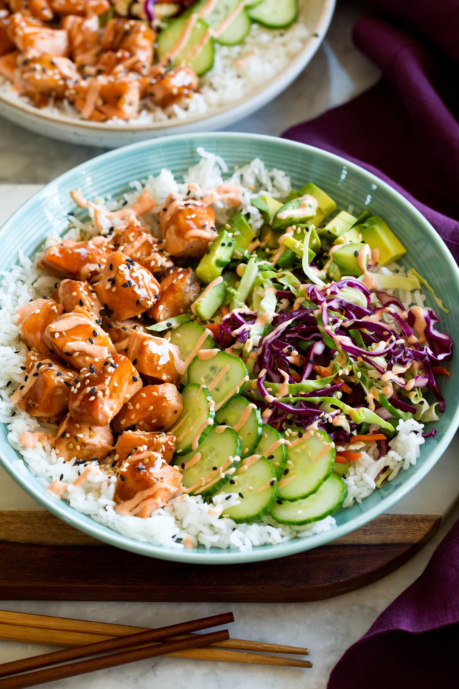 Salmon rice bowl with teriyaki style salmon, cucumber, cabbage, avocado and sriracha mayo.