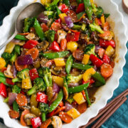 Rainbow stir fried vegetables with sauce in a serving dish.