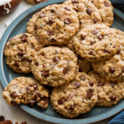 Cowboy cookies stacked on a blue serving plate.