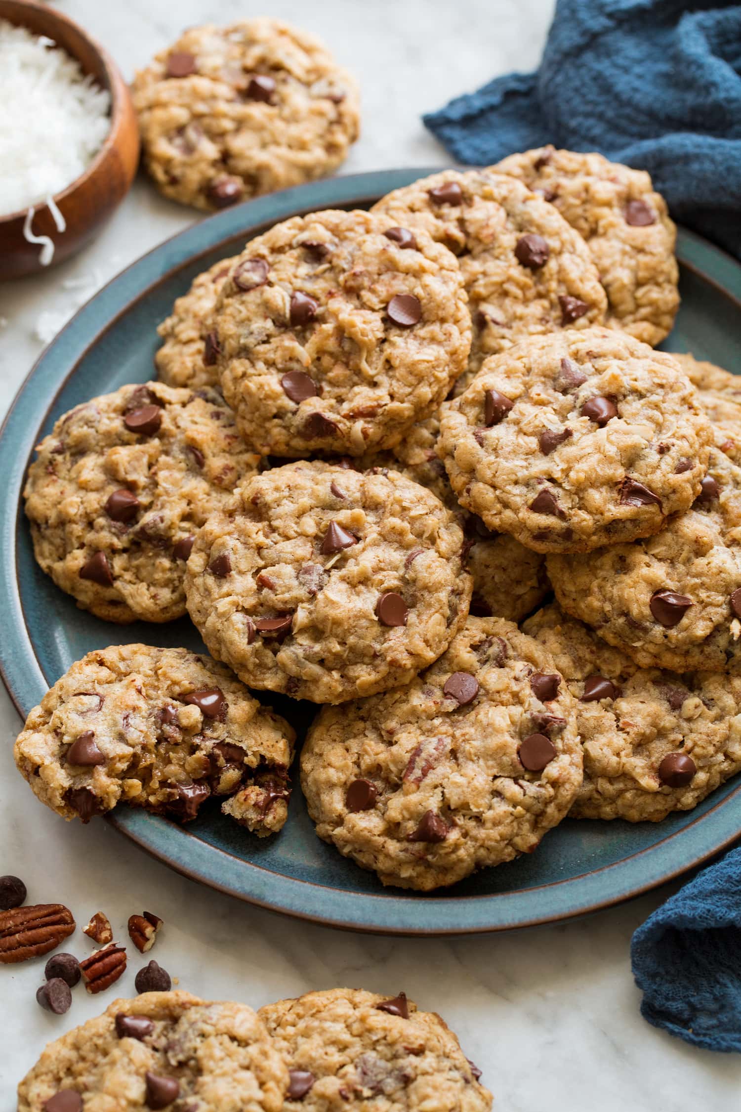 Cowboy cookies stacked on a blue serving plate.