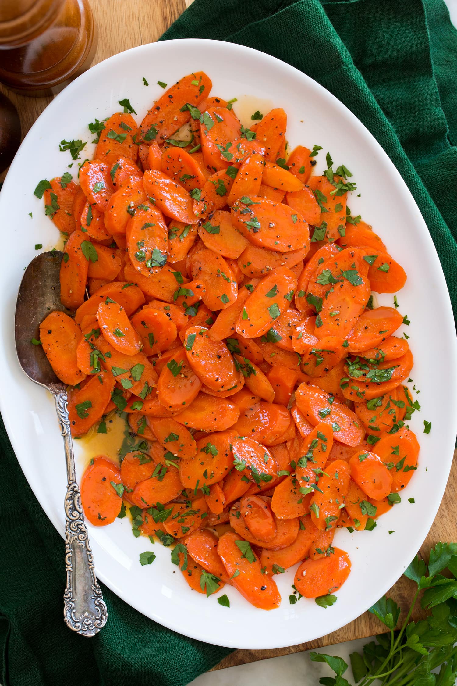 Overhead photo of glazed carrots in a white oval serving dish.