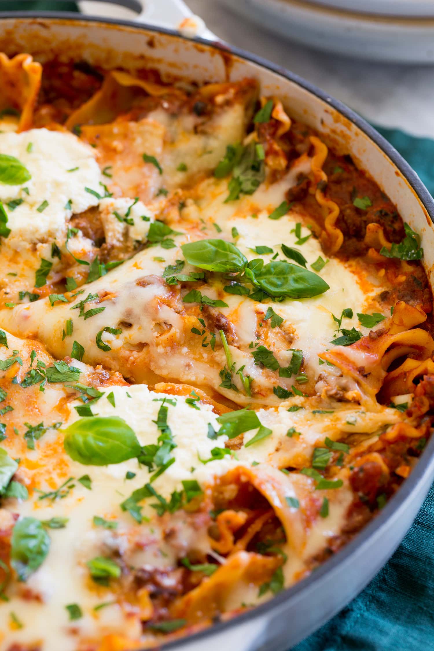 Close up photo of lasagna in large enameled skillet.