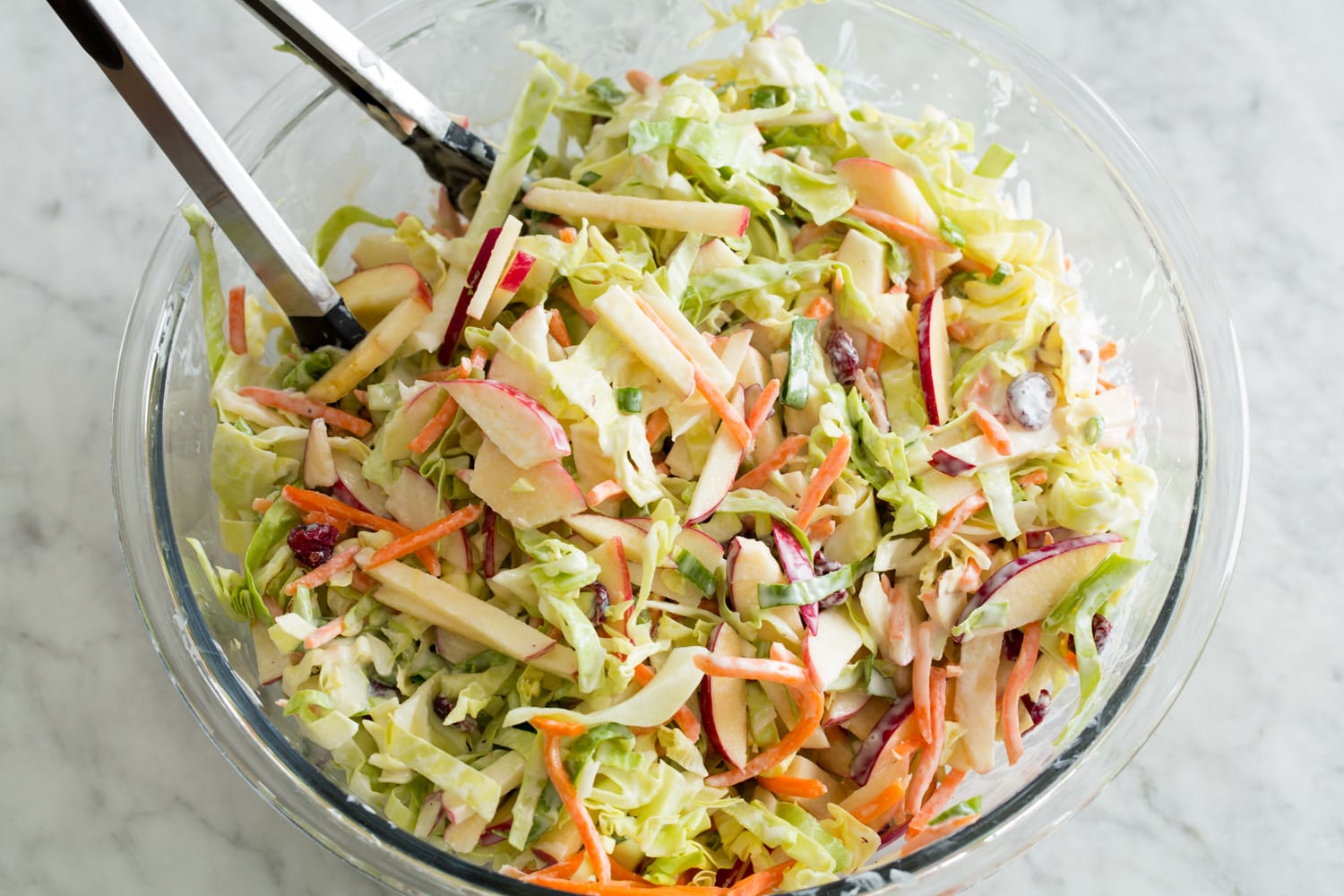 Finished apple slaw in large glass bowl.