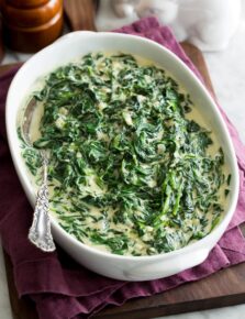 Homemade creamed spinach in a white oval serving dish.