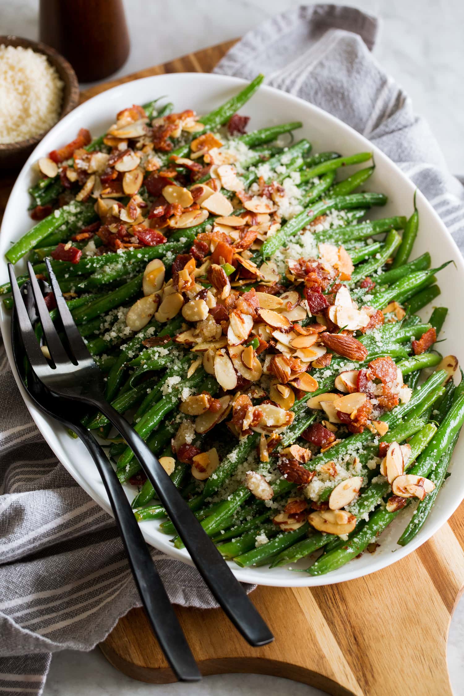 Green bean almondine on a platter shown from a side angle.