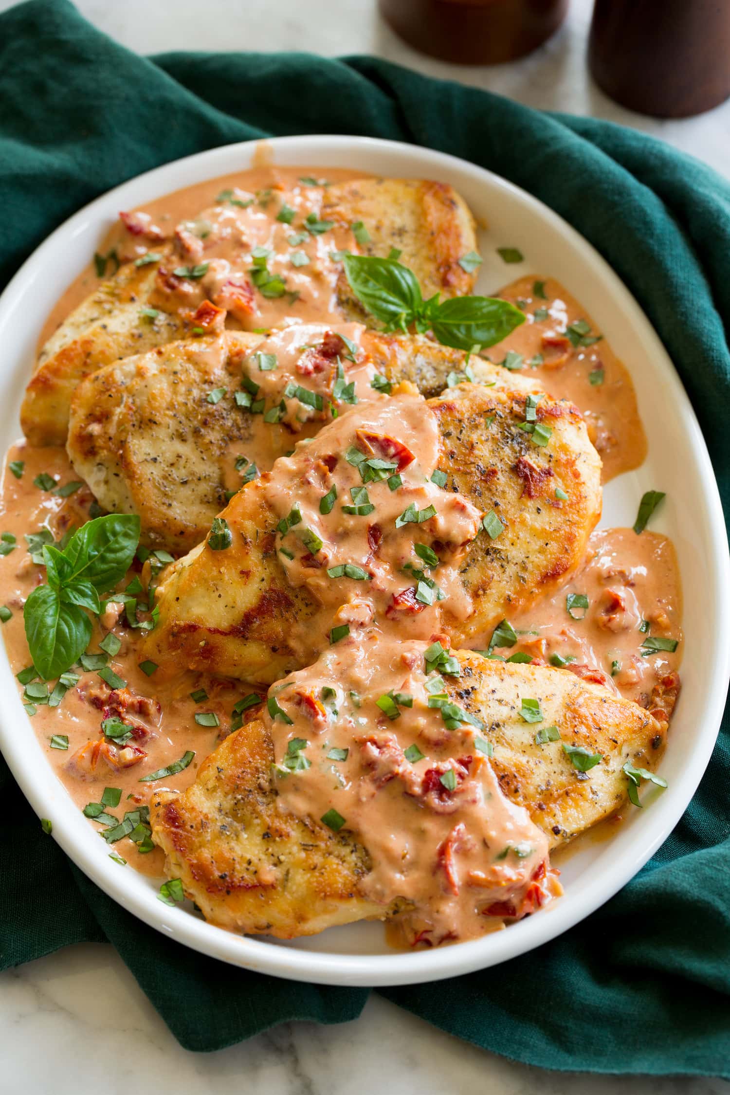 Marry me chicken on a platter. Pan seared chicken breasts are coated with a sun dried tomato basil sauce.