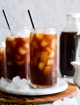 Cold brew with ice shown in glass cups with metal straws.