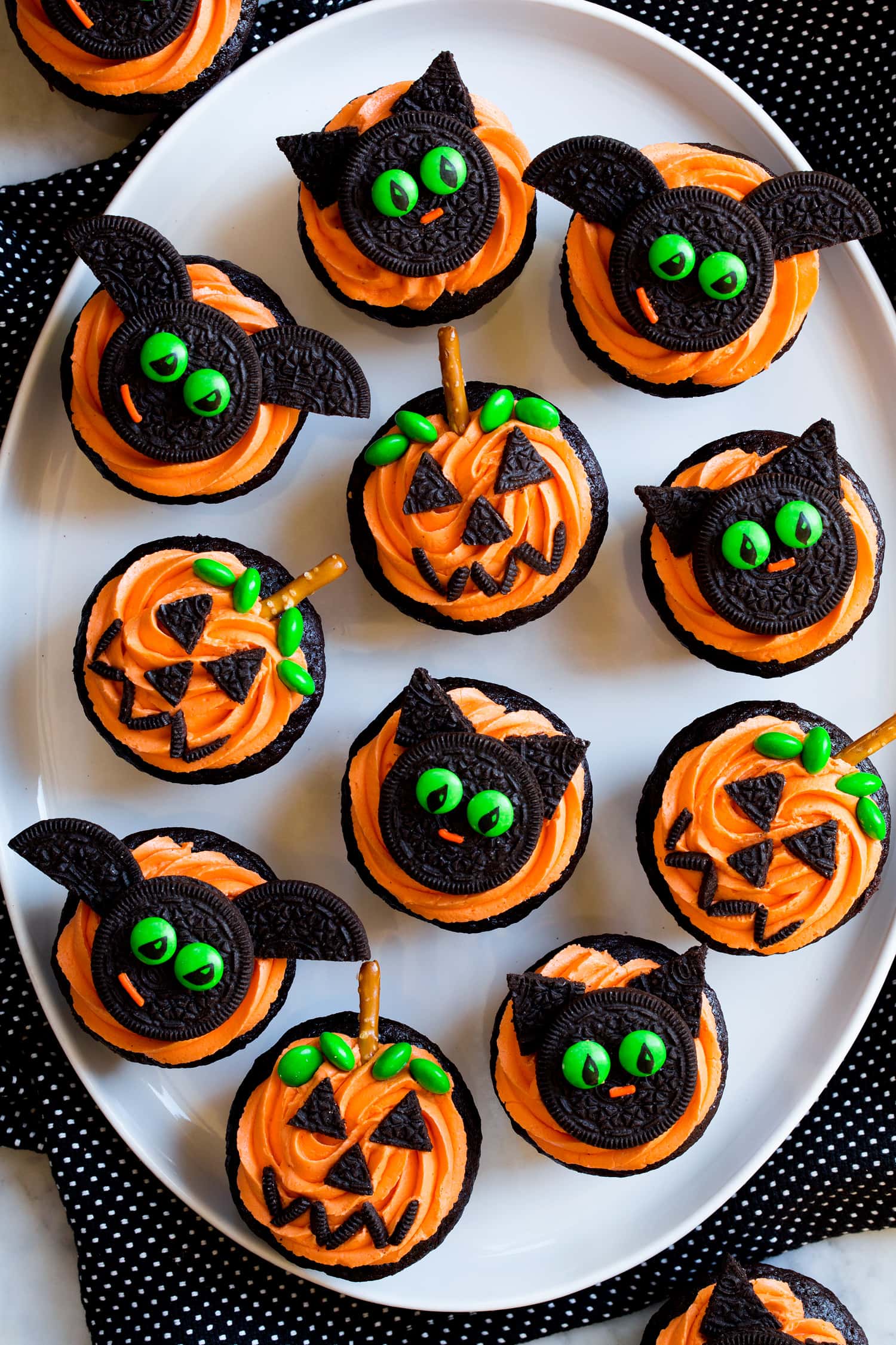 Halloween cupcakes decorated as pumpkins, bats and cats.