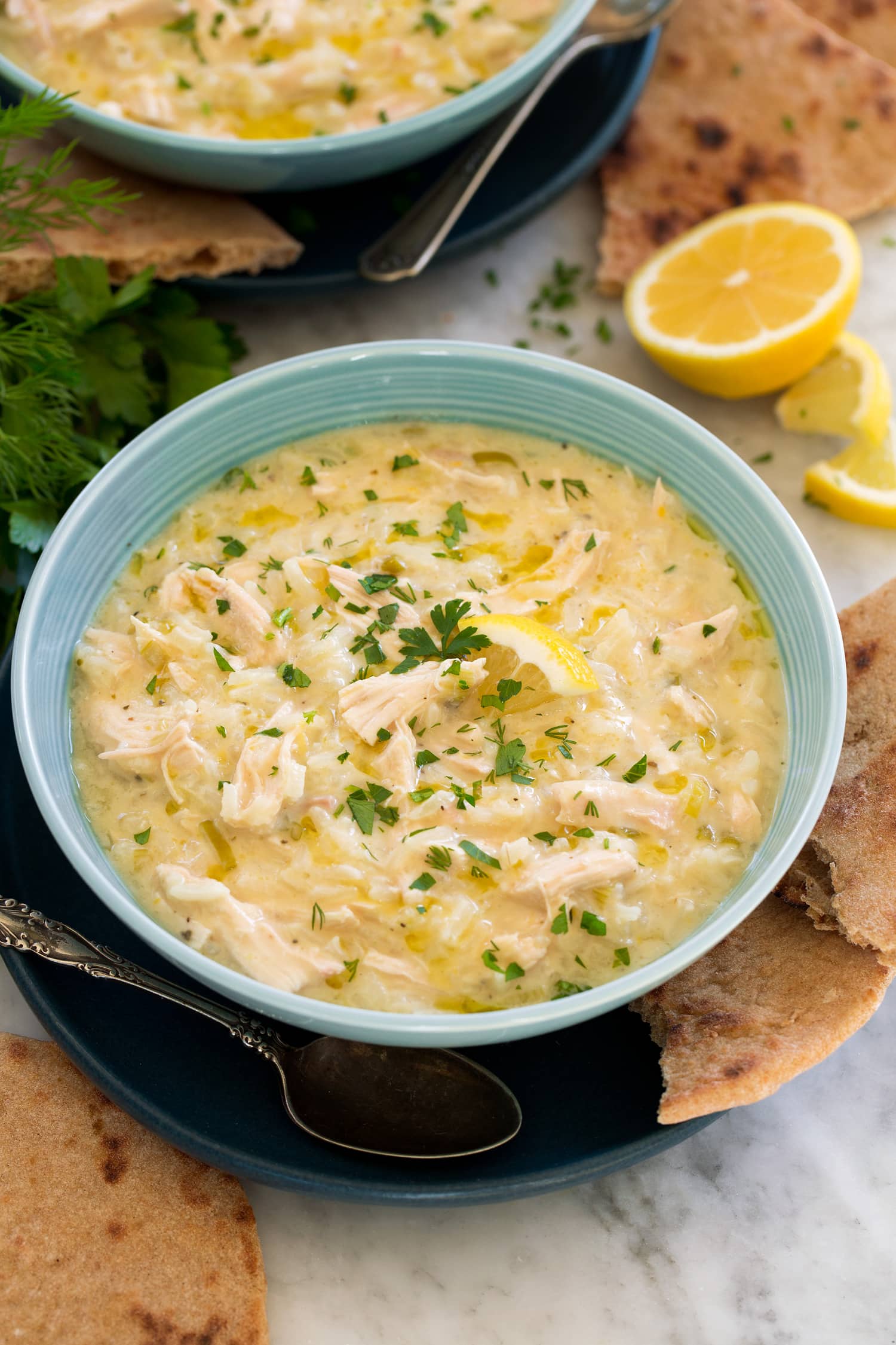 Avgolemono Soup in a turquoise soup bowl.