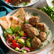 Greek meatballs shown served with tzatziki and greek salad.