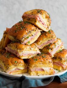 Stack of ham and cheese sliders in a pyramid shape.