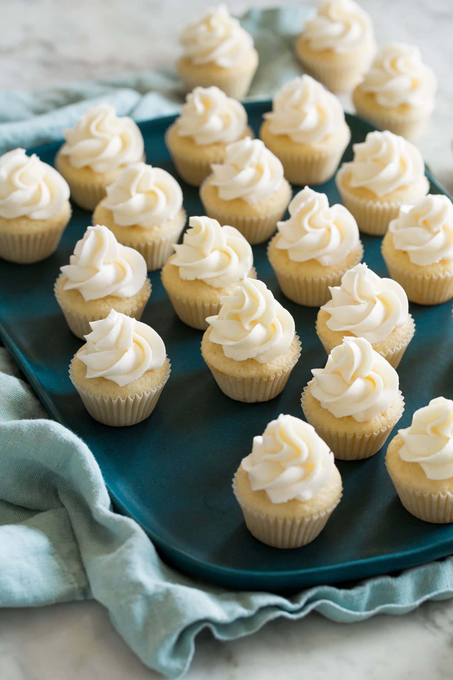 Tray with lots of mini cupcakes with swirled frosting on top.