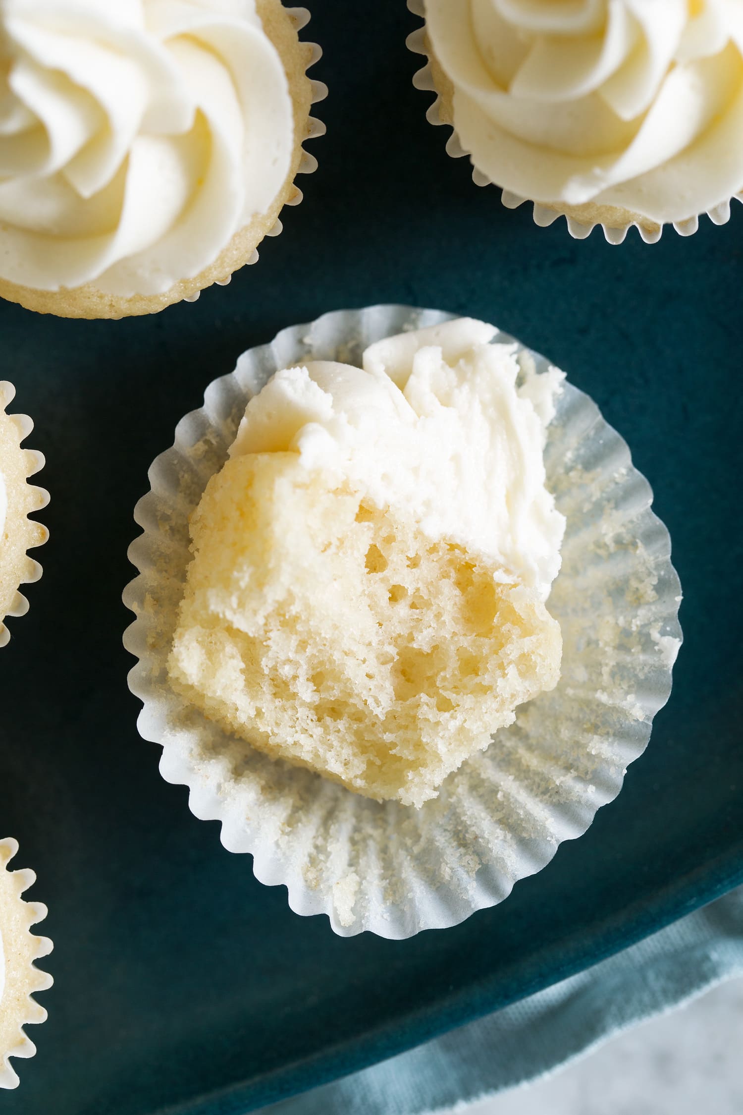 Mini cupcake cut into shown close up to see fluffy texture of crumb.