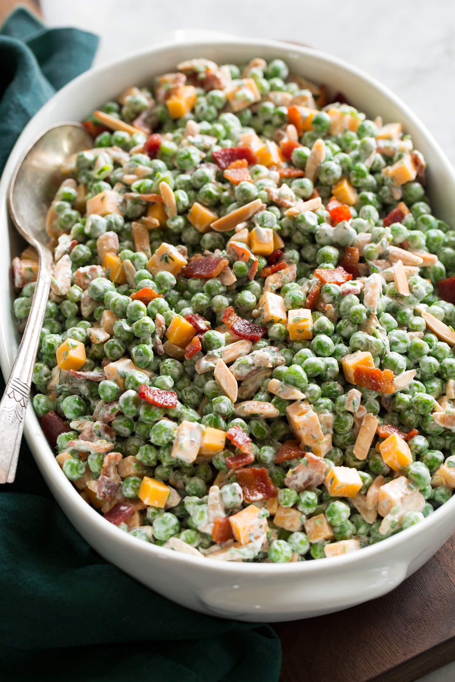 Side angle of pea salad in a white serving dish.