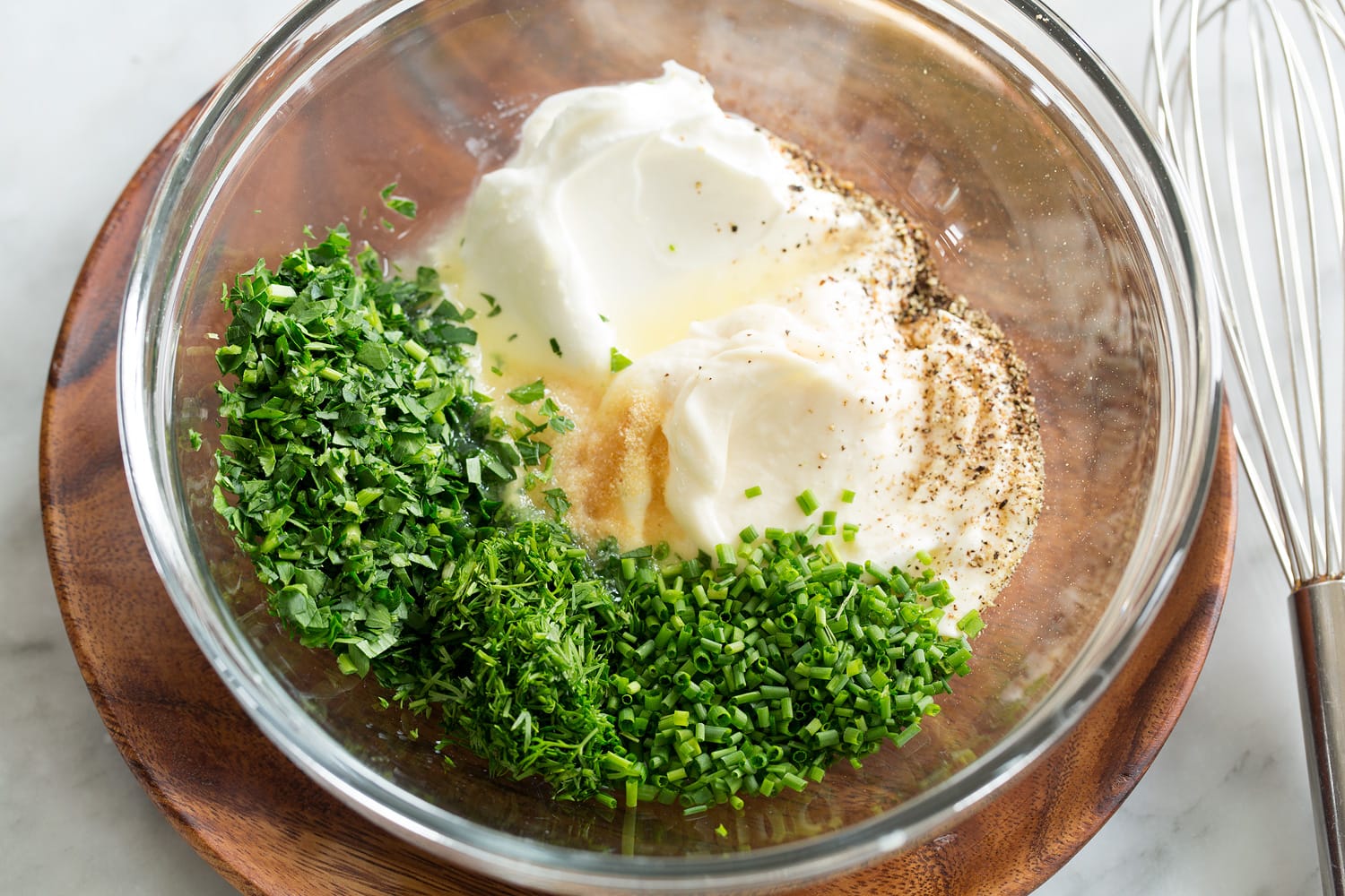 Making creamy pea salad dressing, shown before mixing in a glass bowl.