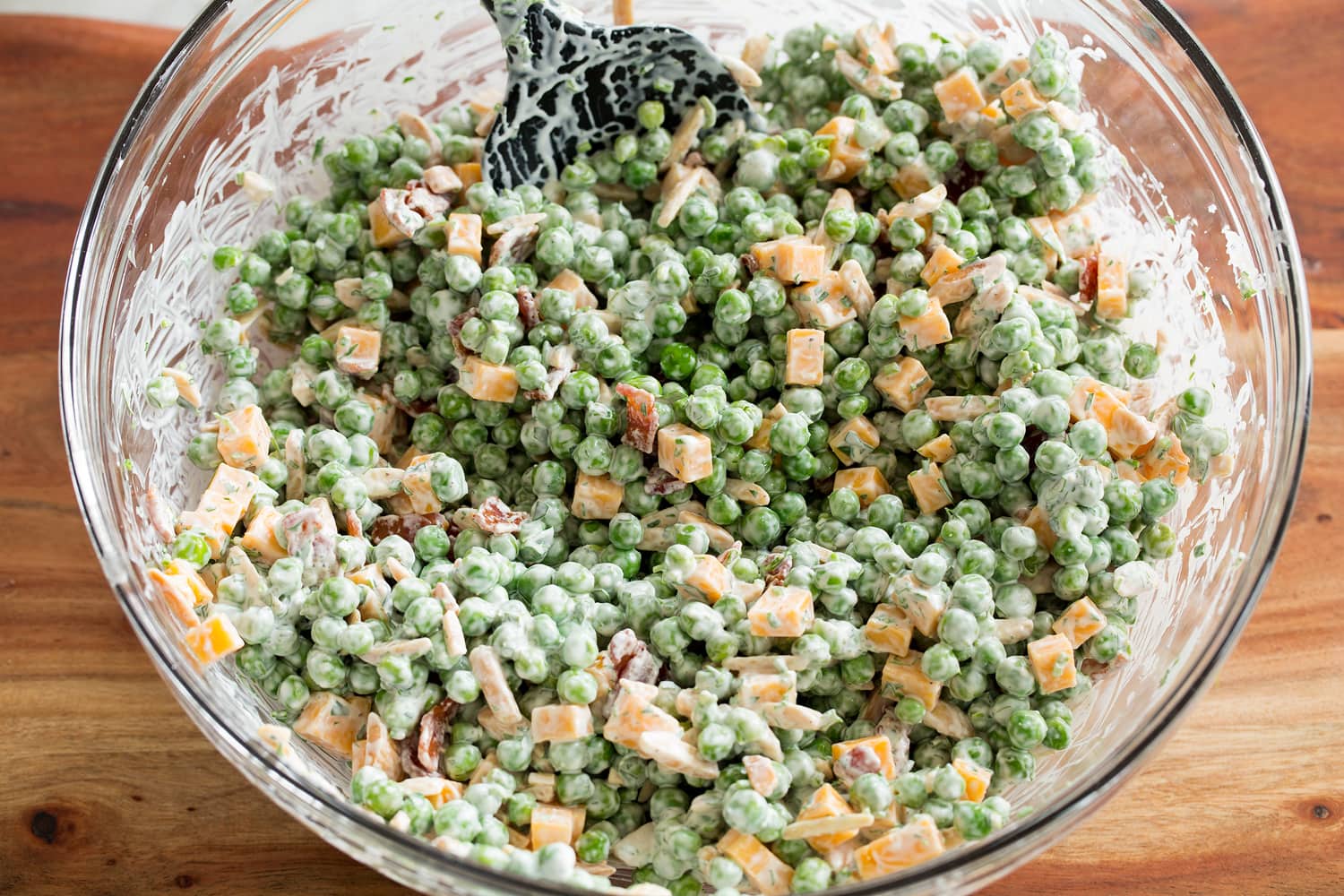 Completed pea salad in a glass mixing bowl.