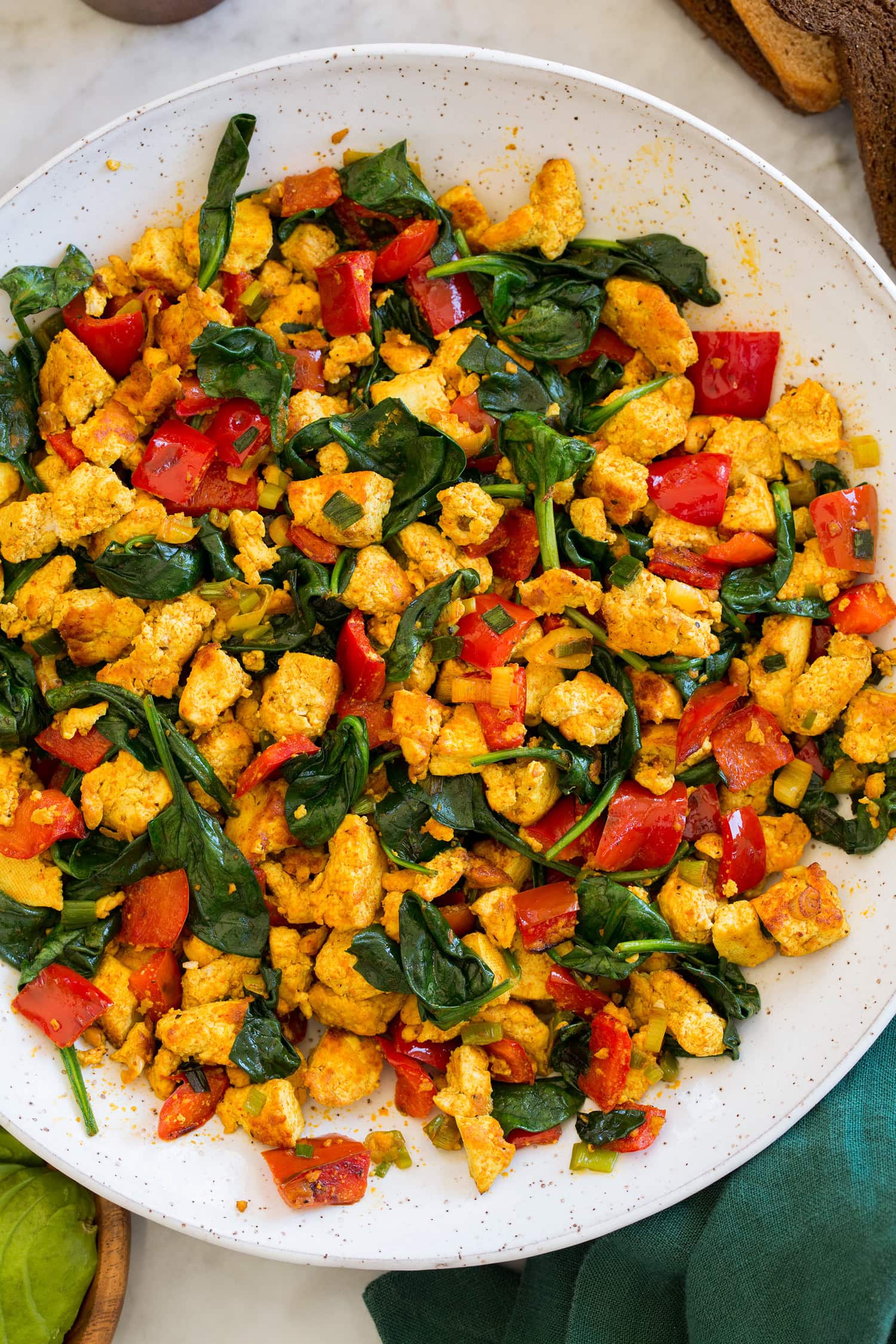 Close up overhead photo of tofu scramble with spinach and bell peppers.