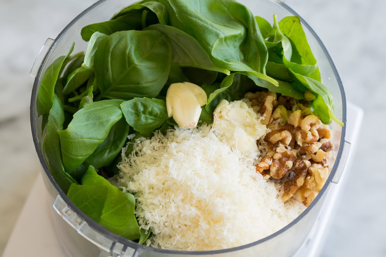 Pesto ingredients in a food processor before mixing.