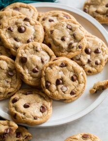 Plate full of browned butter chocolate chip cookies overlapping.